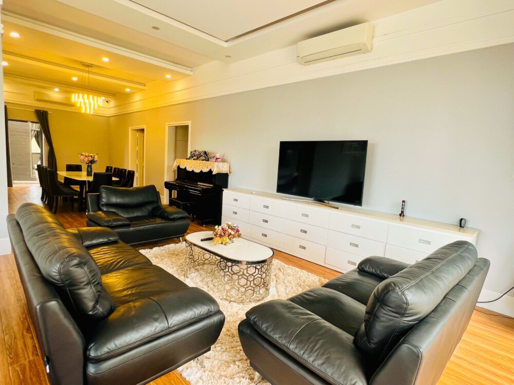 Phòng khách có ghế sofa và tivi để du khách thư giãn tại Odwin TT